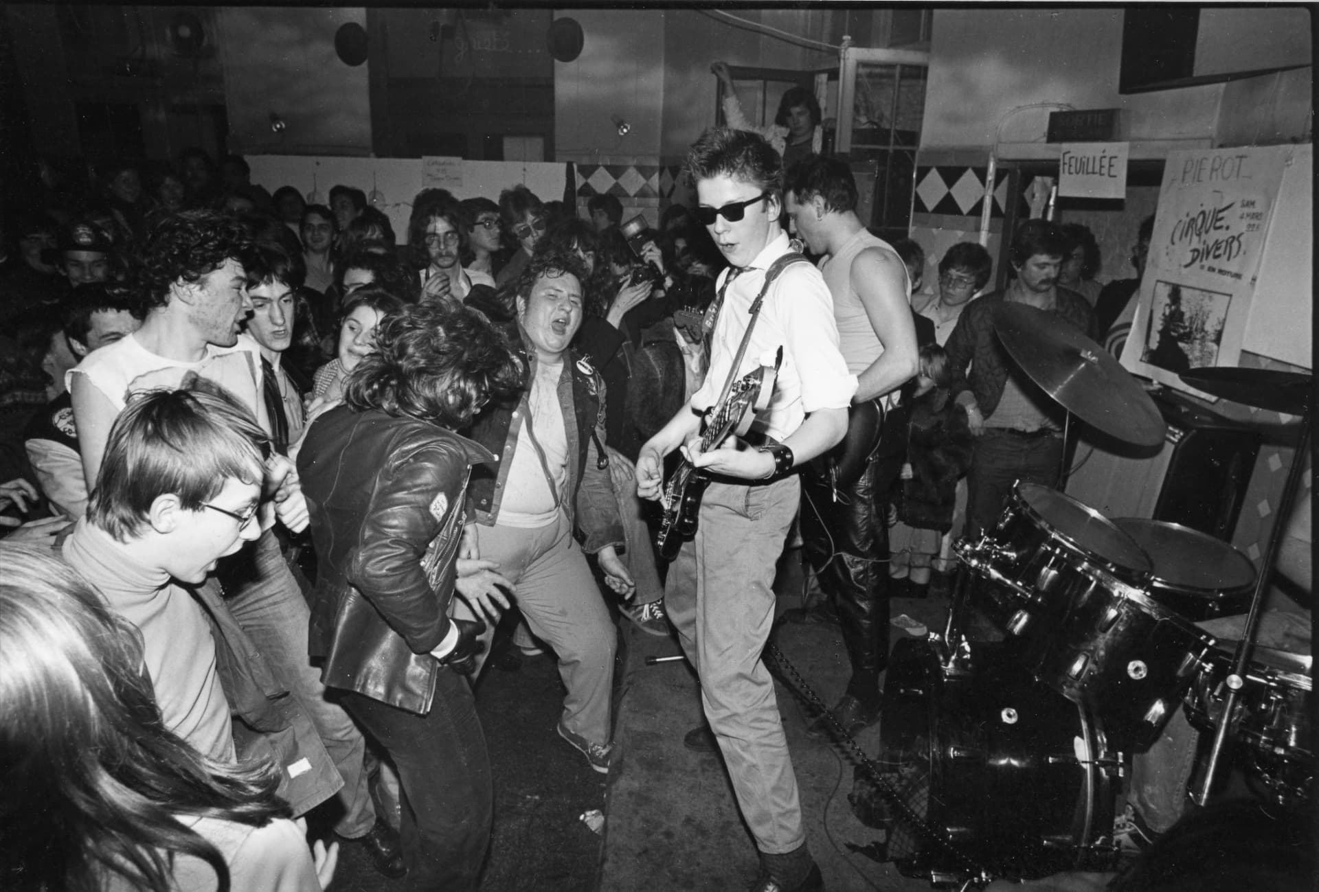 Belgian punk audience and singer photographed in a packed club, 1977
